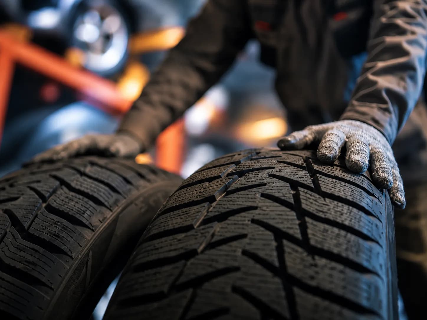 Gloved hands checking the tread of new tyres